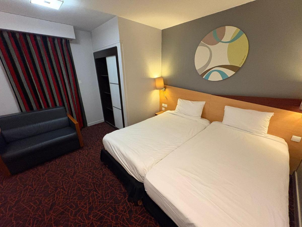 Un ou plusieurs lits dans un hébergement de l'établissement Kyriad Hotel Dijon Gare
