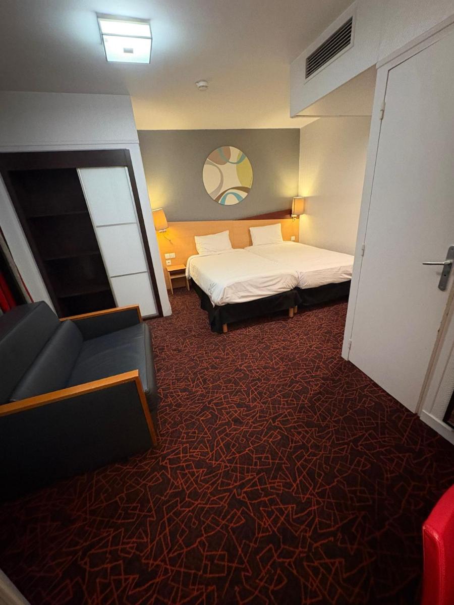 Un ou plusieurs lits dans un hébergement de l'établissement Kyriad Hotel Dijon Gare
