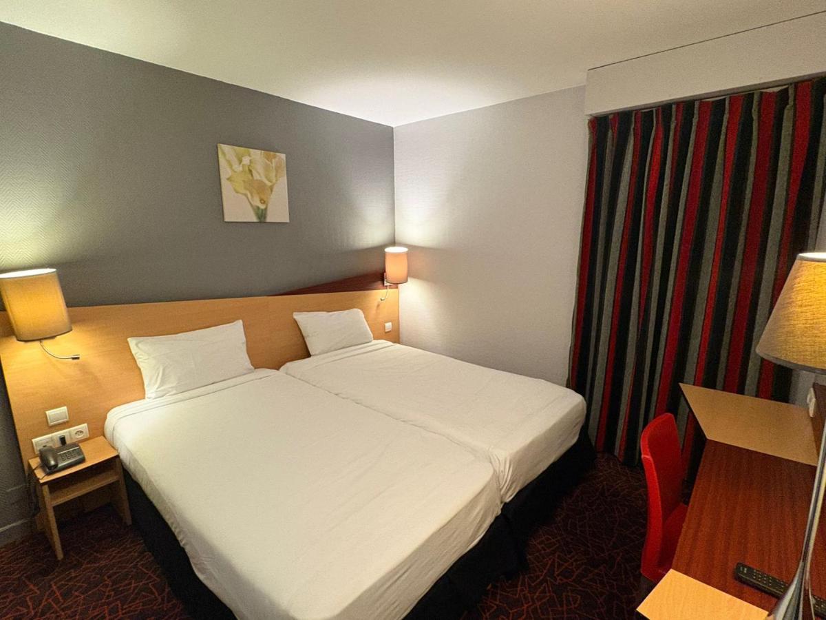 Un ou plusieurs lits dans un hébergement de l'établissement Kyriad Hotel Dijon Gare