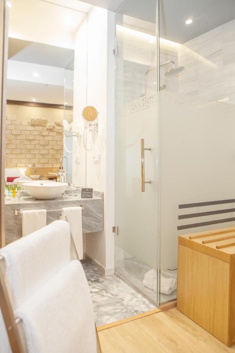 Un baño con ducha de cristal y lavabo. en Soho Boutique Capuchinos & Spa, en Córdoba