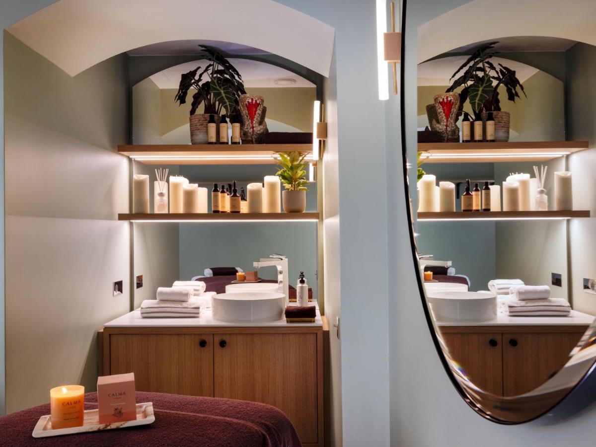 un miroir dans un dressing avec une table et un lavabo dans l'établissement Hôtel De Sers Champs Elysées Paris, à Paris 59 autres photos