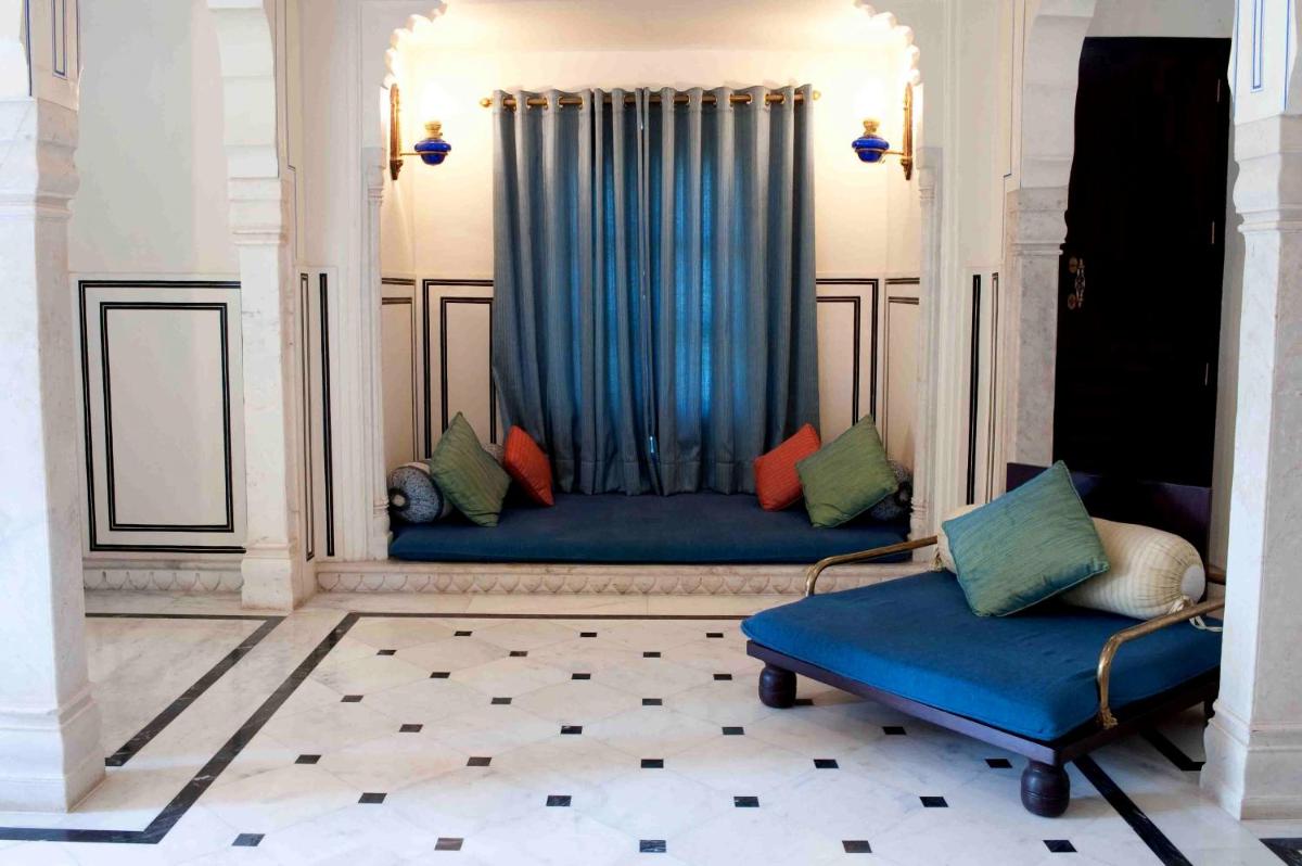a living room with a blue couch with colorful pillows at Royal Heritage Haveli - By Leisure Hotels in Jaipur