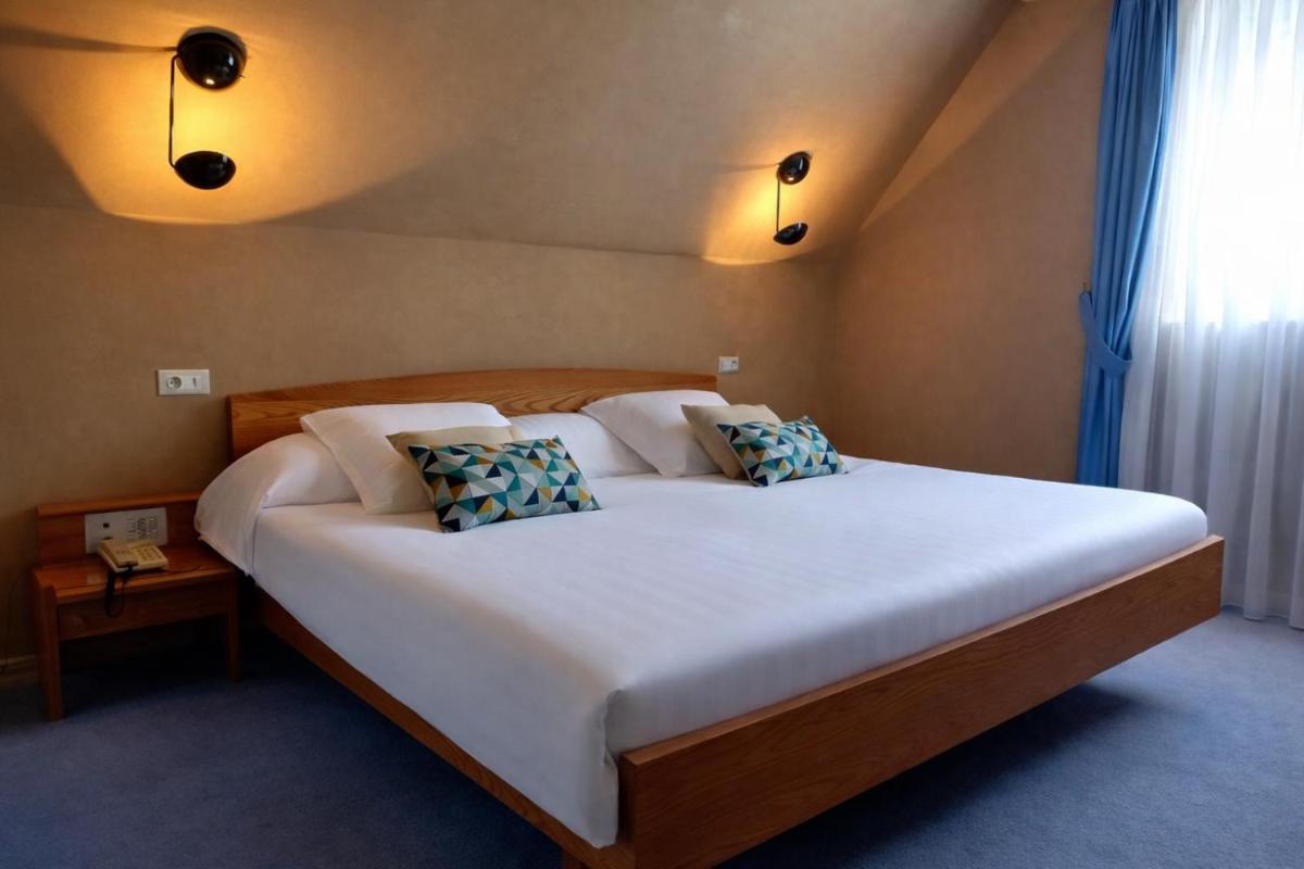 Un ou plusieurs lits dans un hébergement de l'établissement Hotel Munsch Restaurant & Wellness, Colmar Nord - Haut-Koenigsbourg