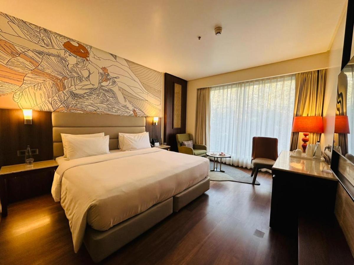 a hotel room with a bed and a painting on the wall at Hyatt Centric Rajpur Road Dehradun in Dehradun