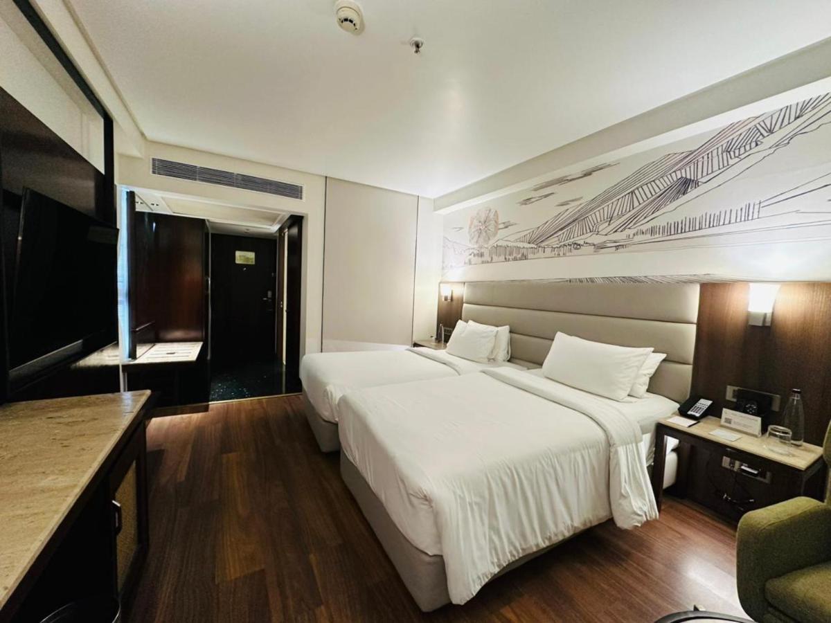 a bedroom with a large white bed and a desk at Hyatt Centric Rajpur Road Dehradun in Dehradun