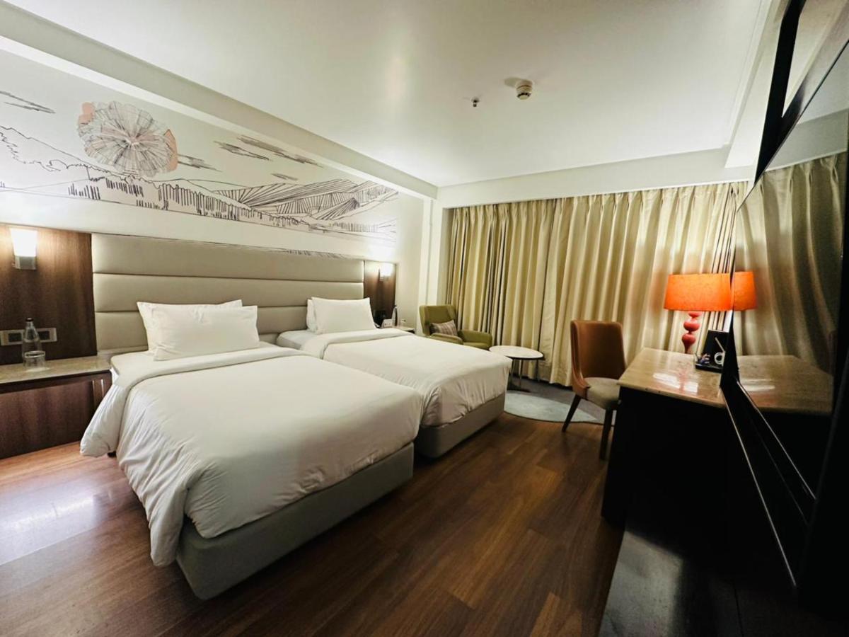 a hotel room with two beds and a desk at Hyatt Centric Rajpur Road Dehradun in Dehradun