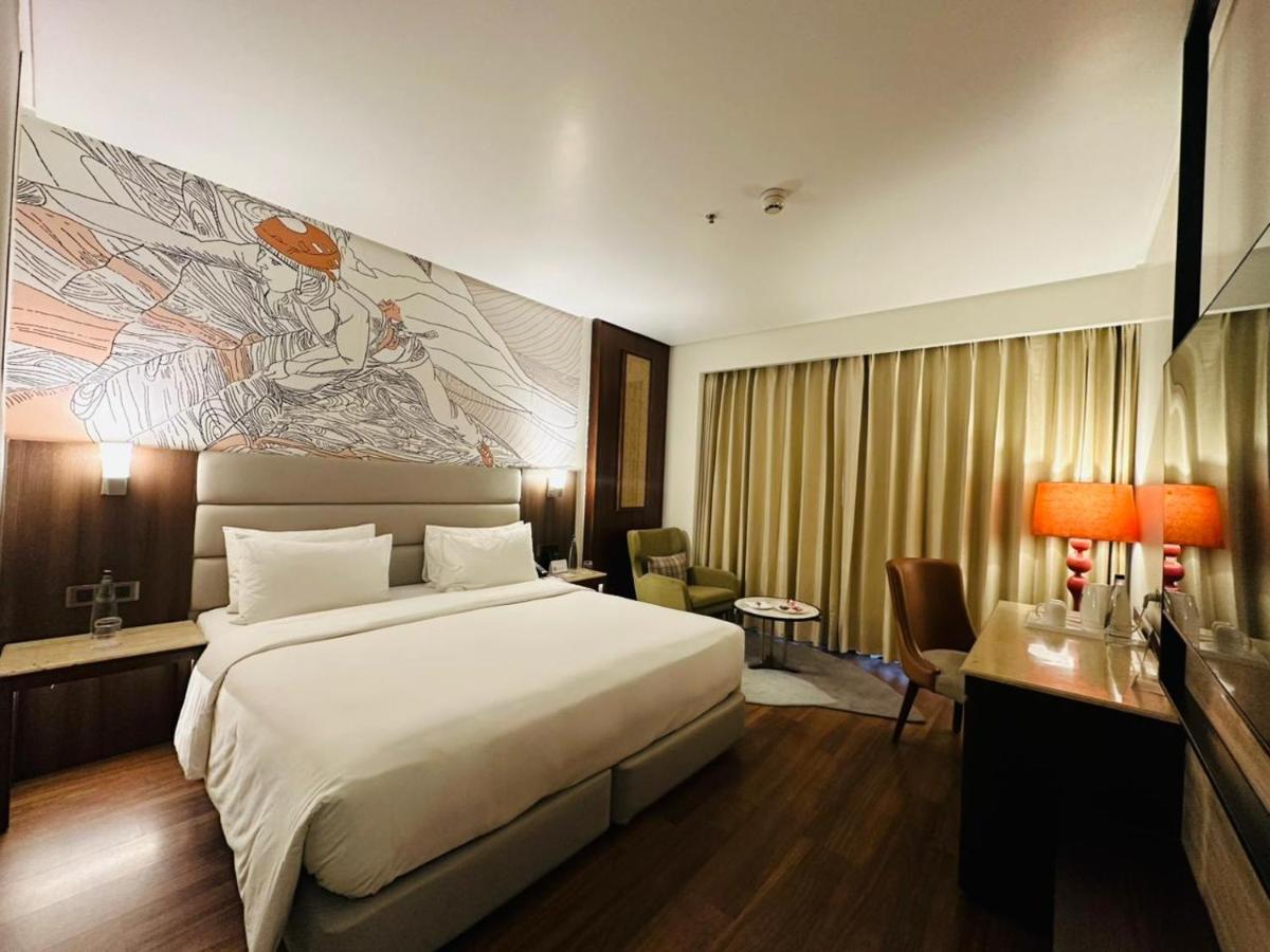 a hotel room with a large bed and a desk at Hyatt Centric Rajpur Road Dehradun in Dehradun