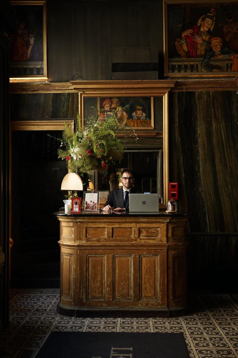 un homme assis à un bureau avec un ordinateur portable dans l'établissement Hotel Les Bains Paris, à Paris 140 autres photos