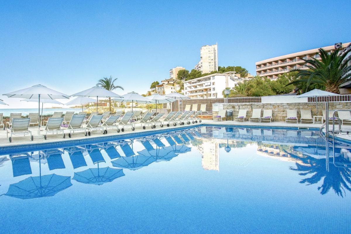 una piscina con sillas y sombrillas en un resort en Hotel Be Live Adults Only Marivent, en Palma de Mallorca