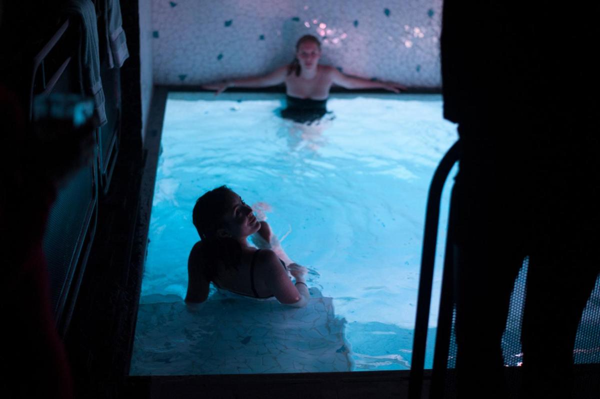 un homme et une femme dans une piscine dans l'établissement Hotel Les Bains Paris, à Paris