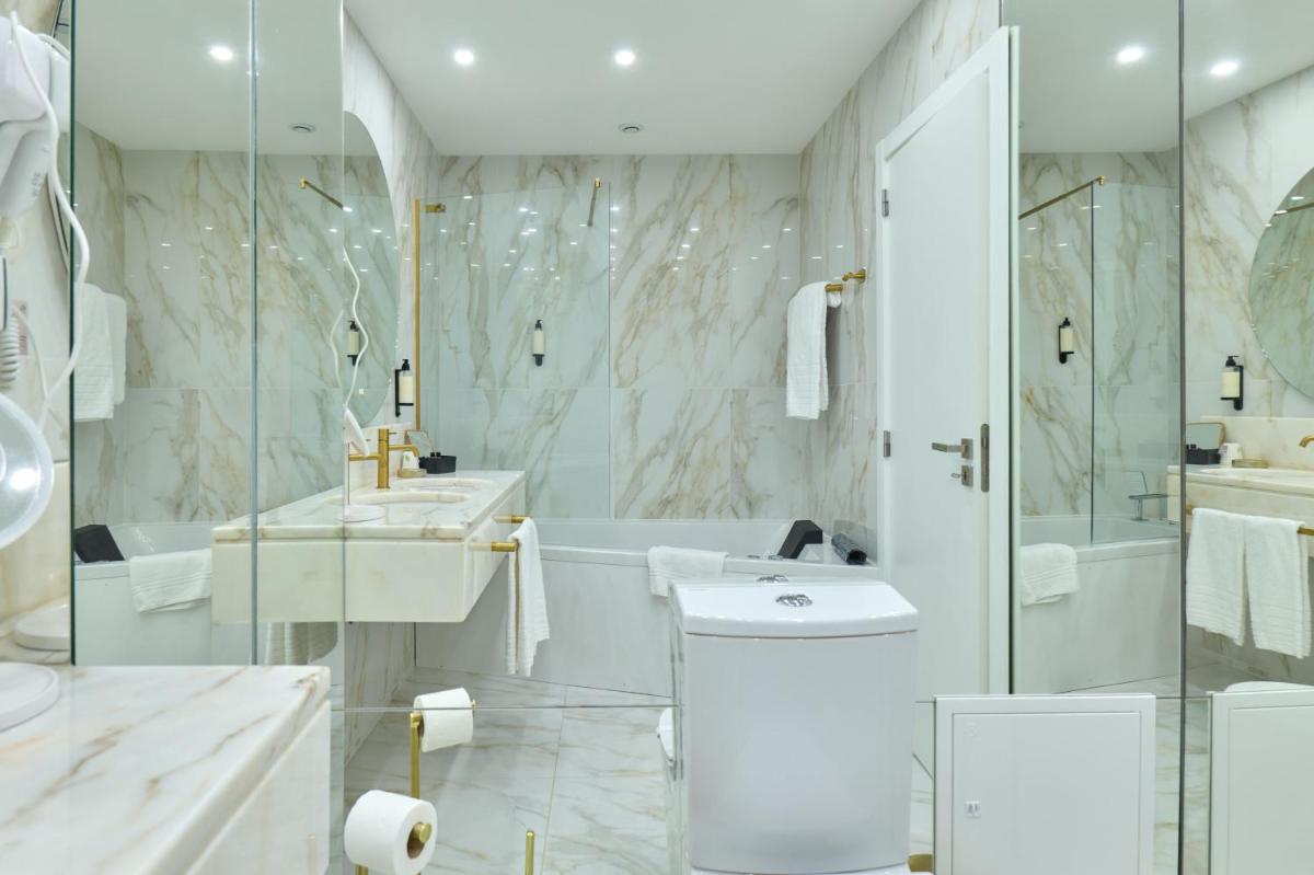 um banheiro branco com banheira e pia em Hotel de Ilhavo Plaza & Spa em Ílhavo mais 133 fotografias