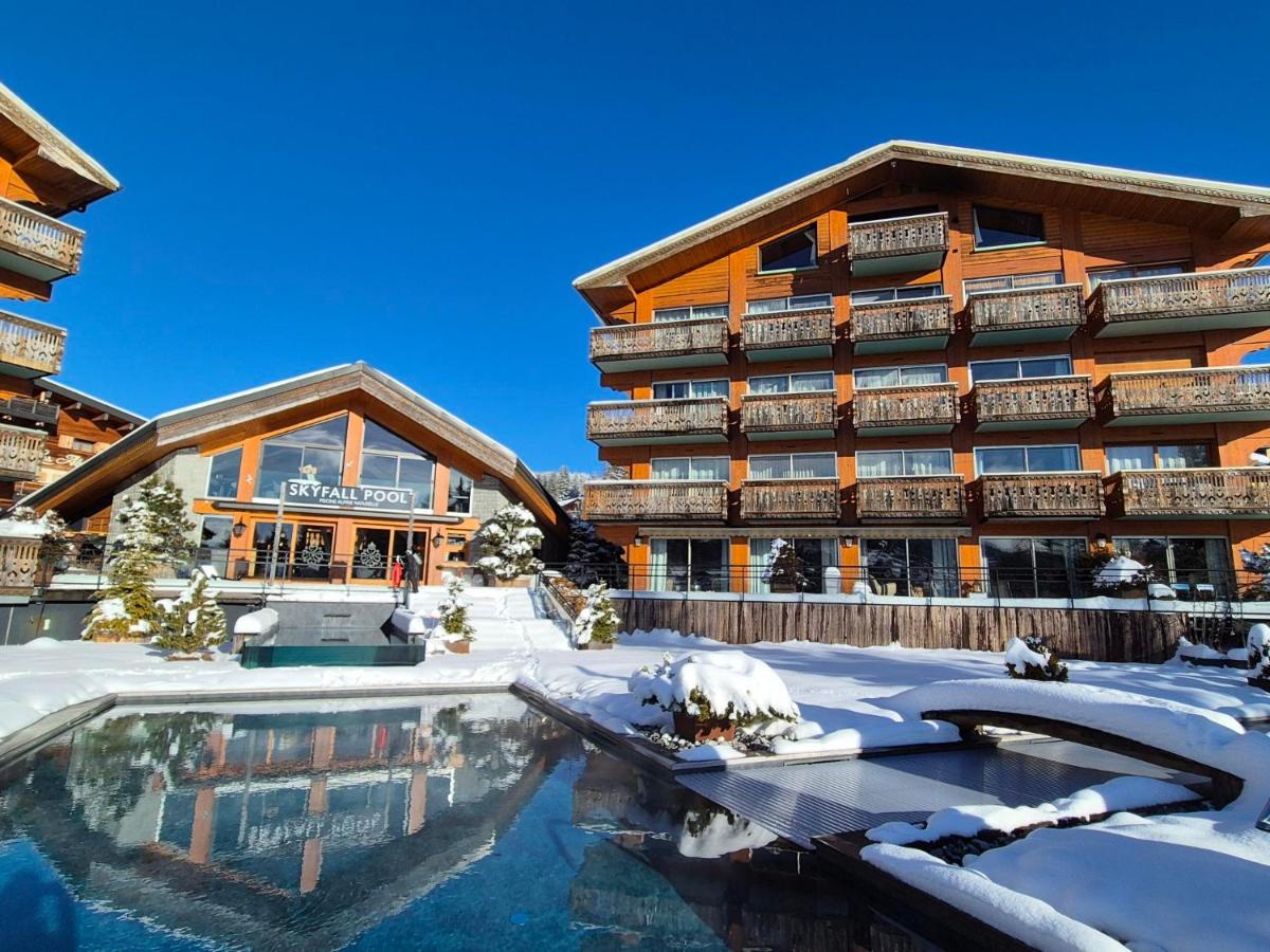 un complexe hôtelier avec une piscine dans la neige dans l'établissement Hôtel Le Labrador 1971, aux Gets