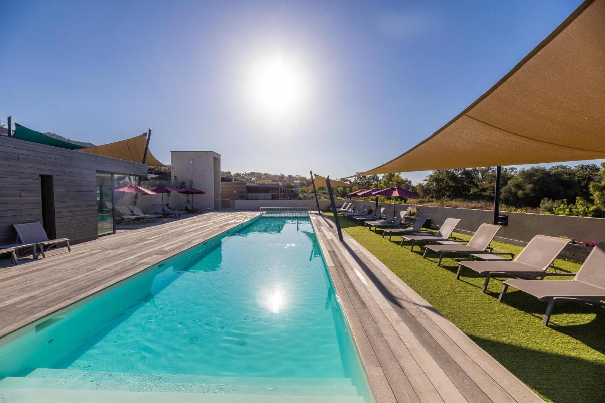 une piscine avec des chaises longues sur un toit dans l'établissement Résidence Pierre & Vacances Premium Les Terrasses d'Arsella, à Porto-Vecchio 80 autres photos