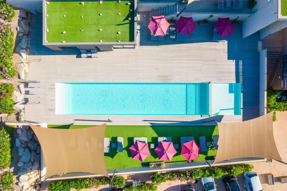 une vue aérienne d'une piscine avec des parasols dans l'établissement Résidence Pierre & Vacances Premium Les Terrasses d'Arsella, à Porto-Vecchio
