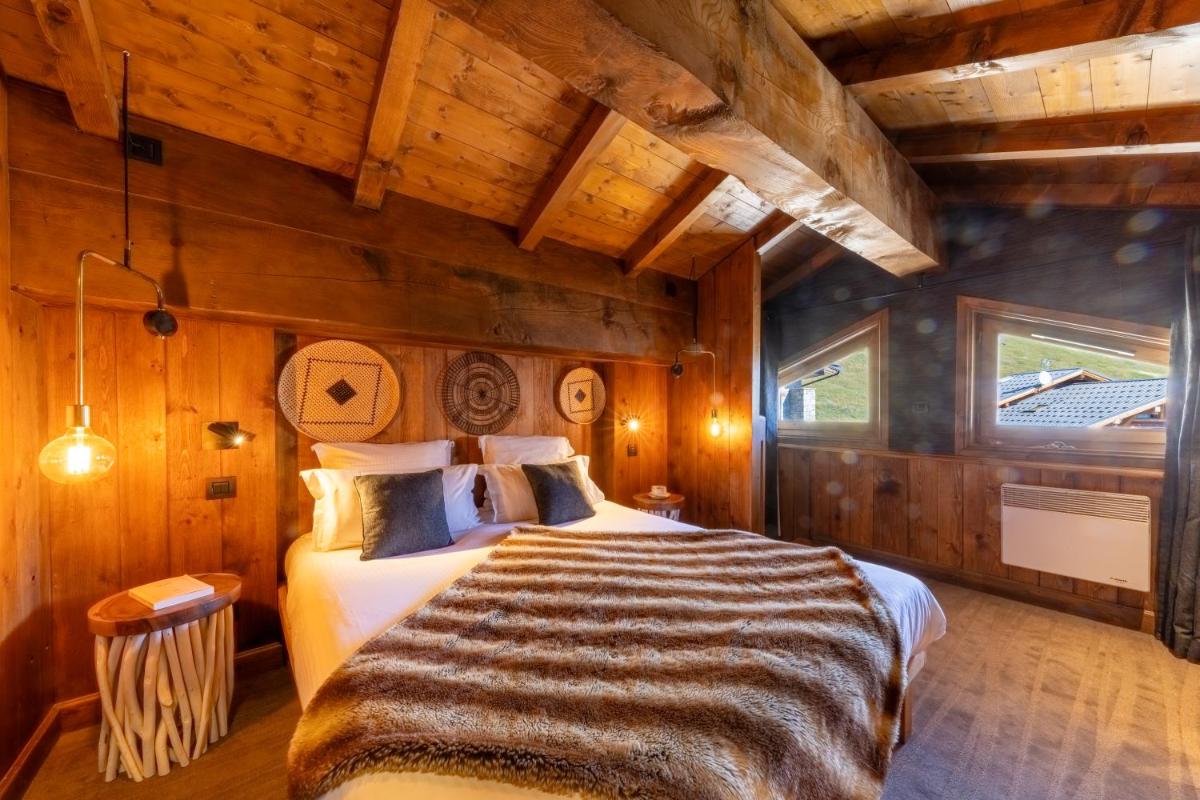 une chambre avec un lit dans une pièce aux murs en bois dans l'établissement Hôtel Village Montana by Les Etincelles, à Tignes 86 autres photos