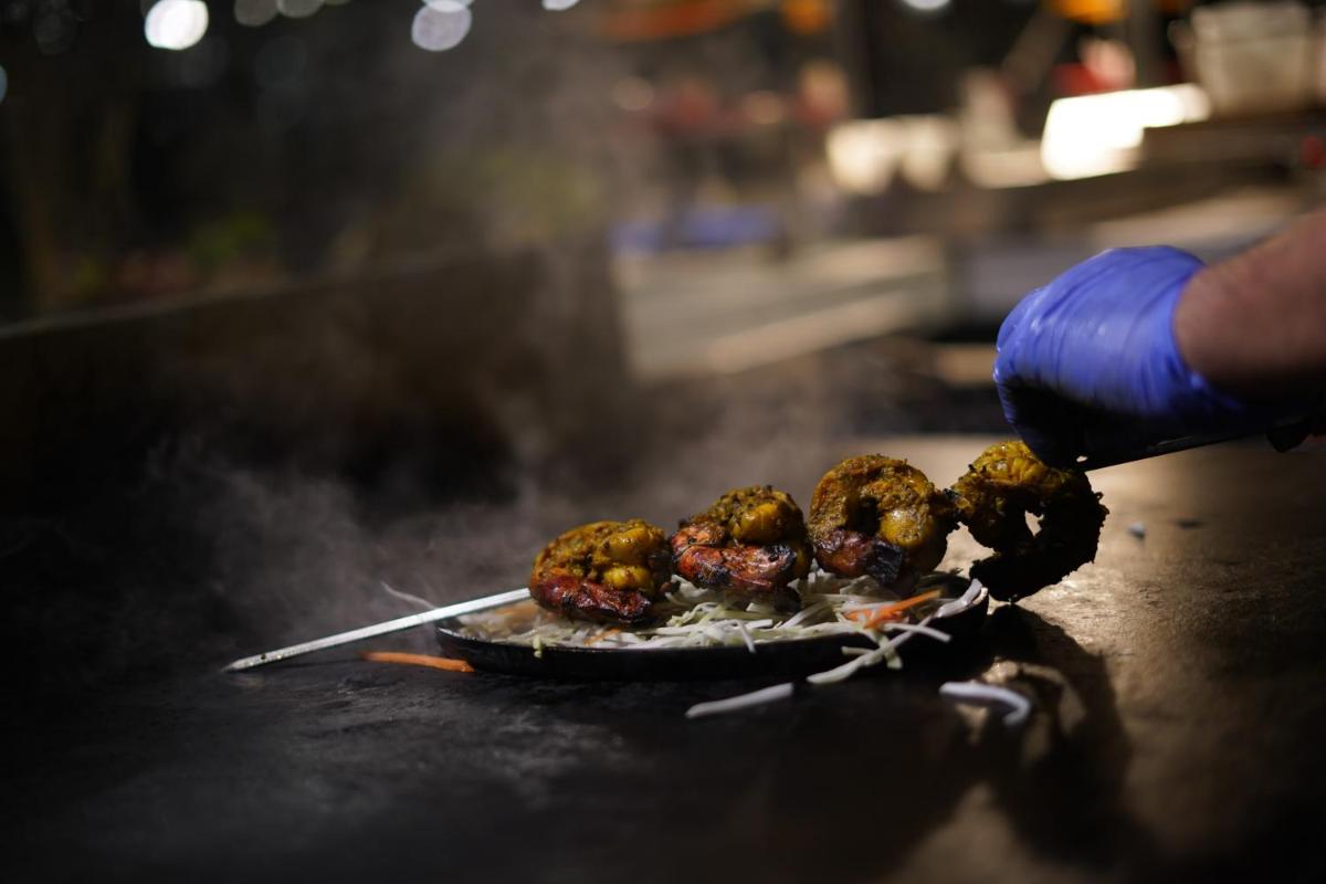 a person is cooking food on a grill at Courtyard by Marriott Gurugram Downtown in Gurgaon