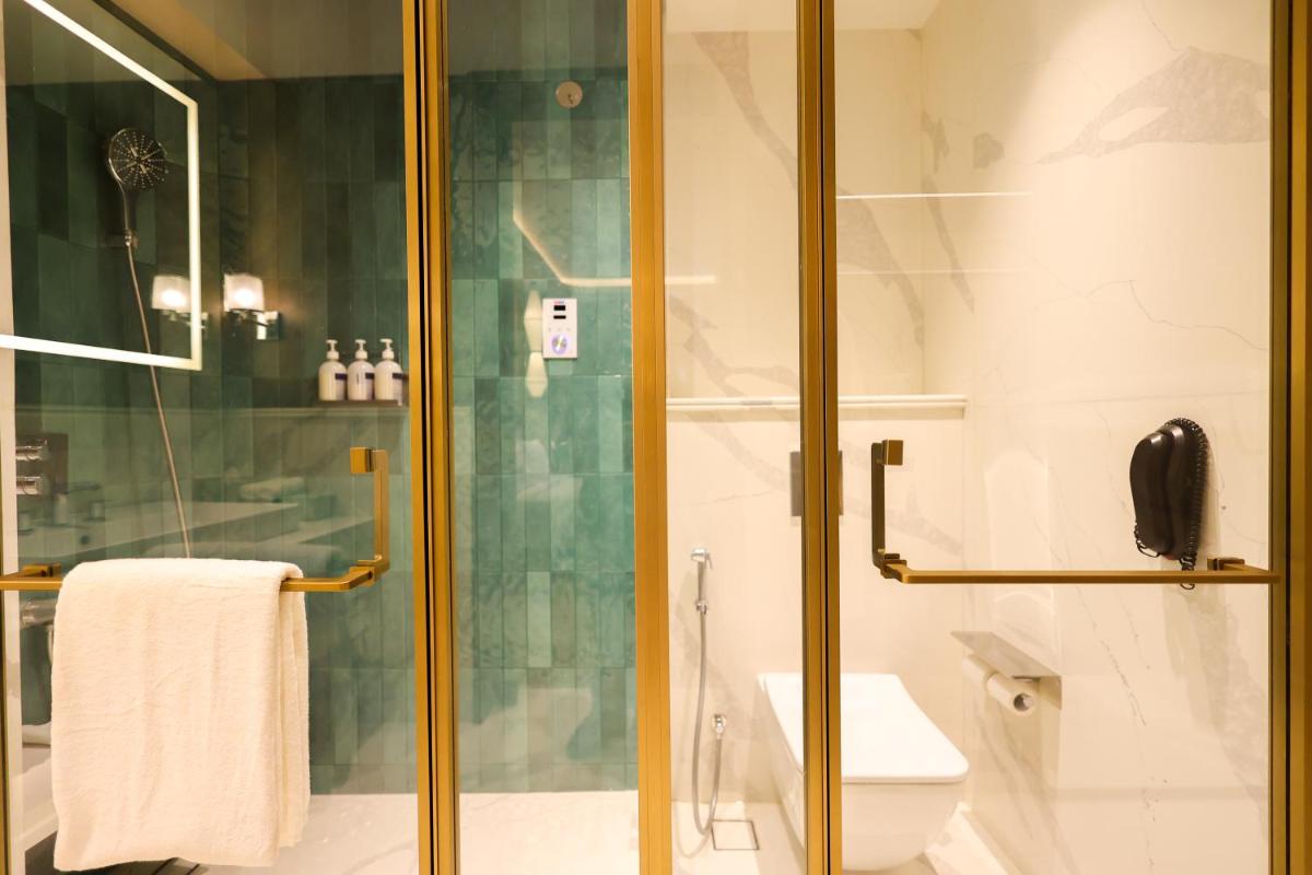 a bathroom with a glass shower with a toilet at Holiday Inn New Delhi Mayur Vihar Noida by IHG in New Delhi a bathroom with a glass shower with a toilet at Holiday Inn New Delhi Mayur Vihar Noida by IHG in New Delhi