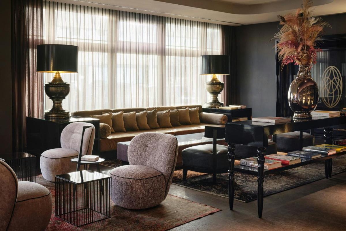 ein Wohnzimmer mit Sofa und Stühlen in der Unterkunft Roomers Frankfurt Central, Autograph Collection in Frankfurt am Main
