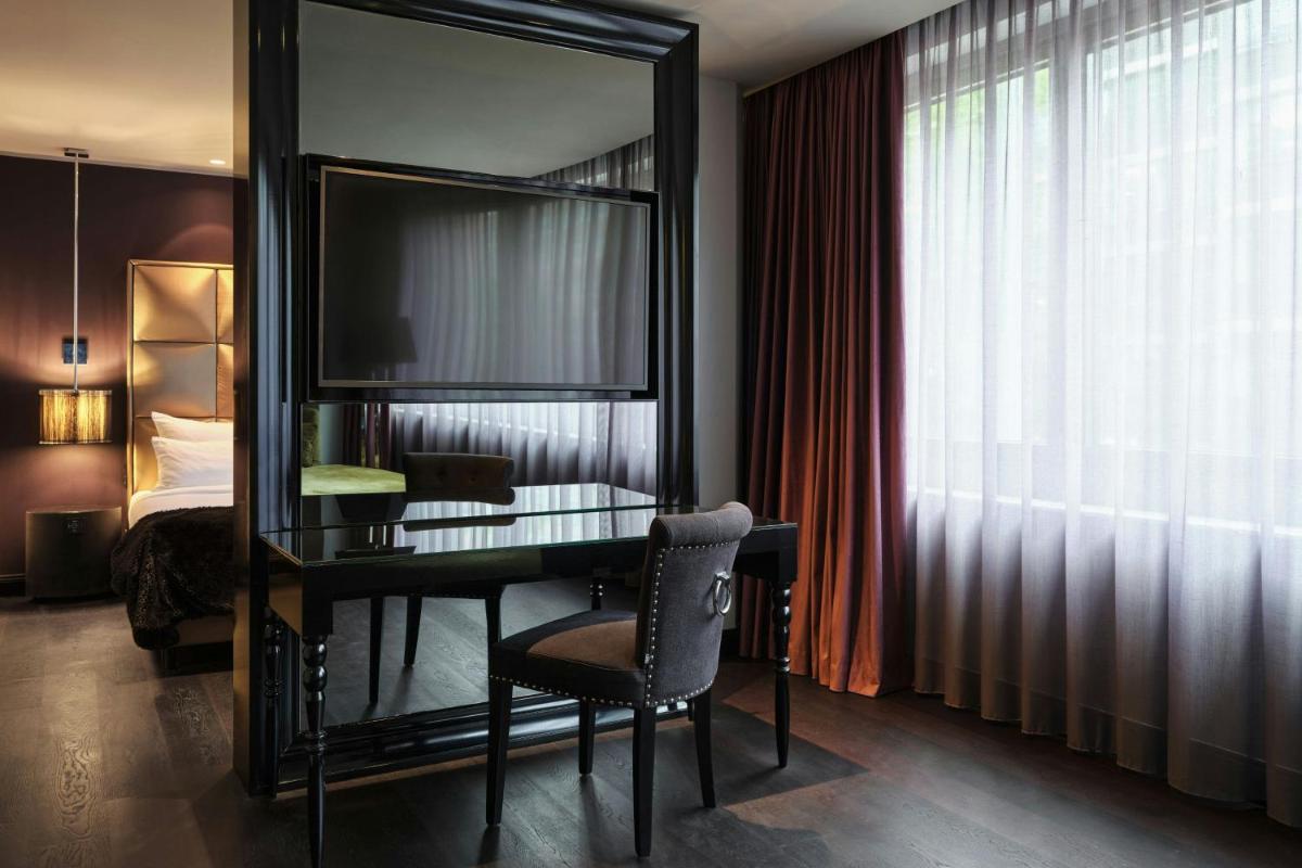 ein Schreibtisch in einem Hotelzimmer mit einem Spiegel in der Unterkunft Roomers Frankfurt Central, Autograph Collection in Frankfurt am Main + 53 Fotos