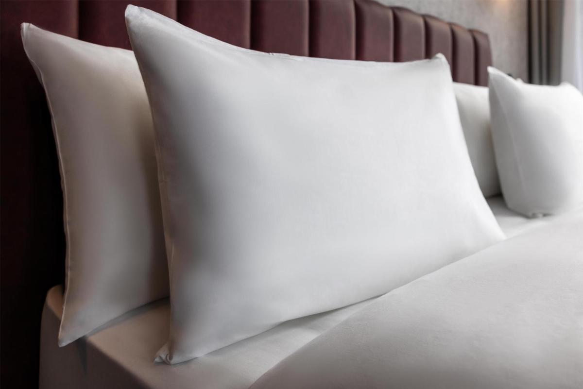 a pile of white pillows on a bed at Radisson Blu Kochi in Cochin