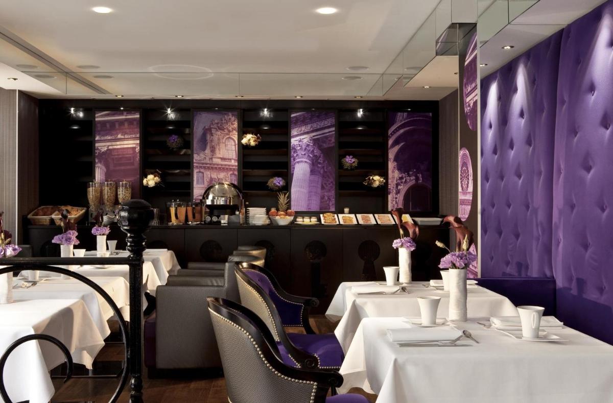une salle à manger avec des tables blanches et des murs violets dans l'établissement Secret de Paris - Hotel & Spa, à Paris