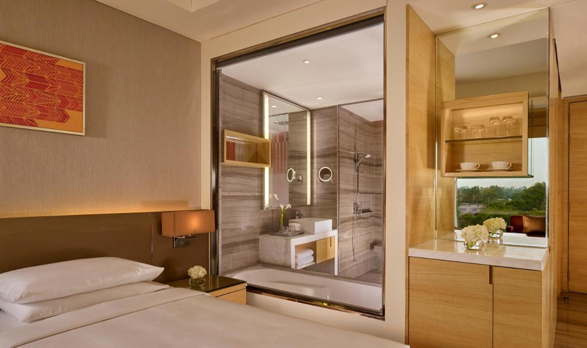 a bedroom with a bed and a shower and a bathroom at Hyatt Regency Chandigarh in Chandīgarh
