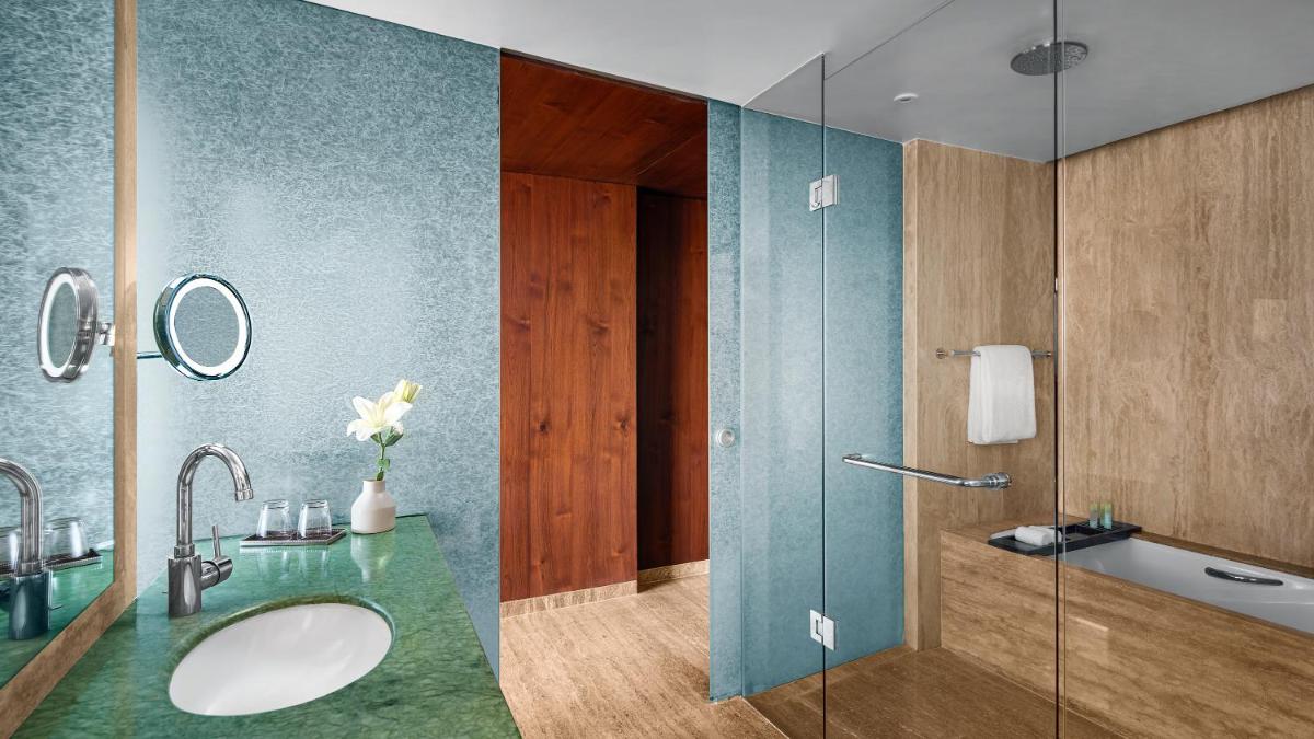 a bathroom with a sink and a glass shower at Park Hyatt Chennai in Chennai