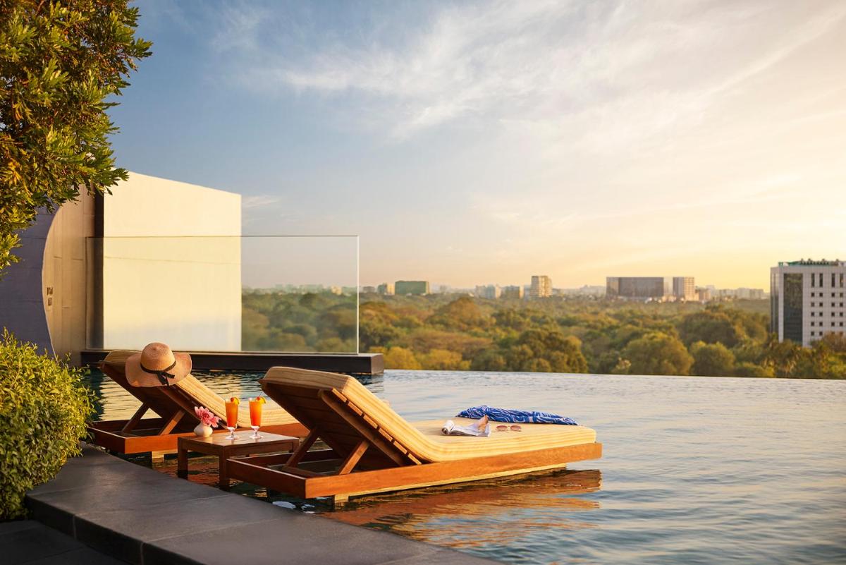a patio with chairs and a table on the water at Park Hyatt Chennai in Chennai