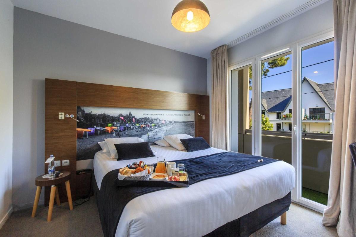 une chambre d'hôtel avec un lit et un plateau-repas dessus dans l'établissement Best Western Hôtel Garden and Spa, à La Baule 40 autres photos