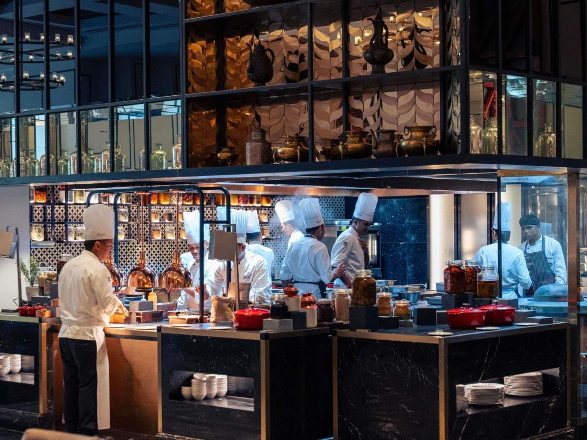 a group of chefs preparing food in a kitchen at Fairmont Mumbai in Mumbai