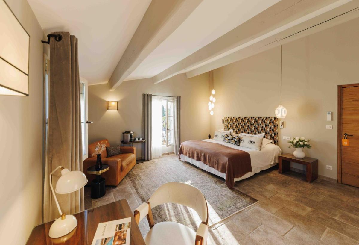 une chambre d'hôtel avec un lit, une table et des chaises dans l'établissement Hôtel La Dimora & Spa, à Saint-Florent