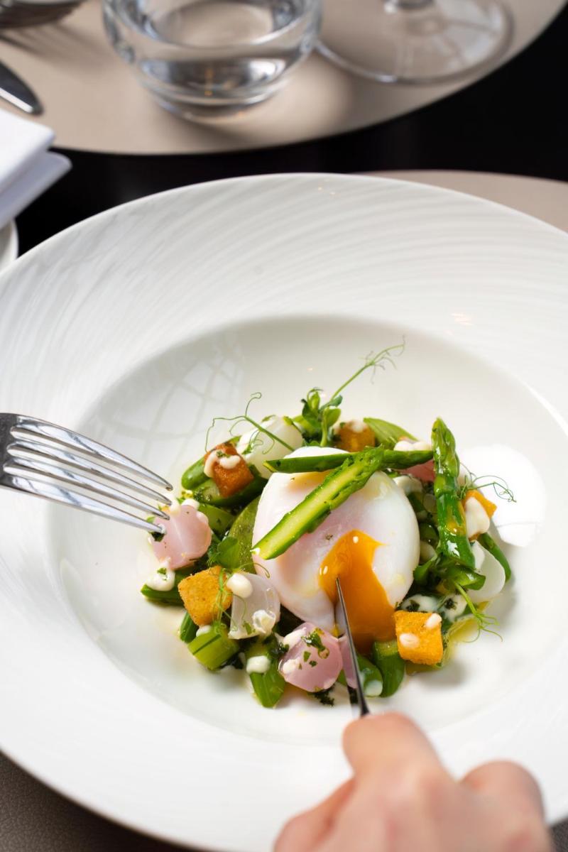 une assiette de nourriture avec un œuf dessus dans l'établissement Waldorf Astoria Versailles - Trianon Palace, à Versailles 137 autres photos