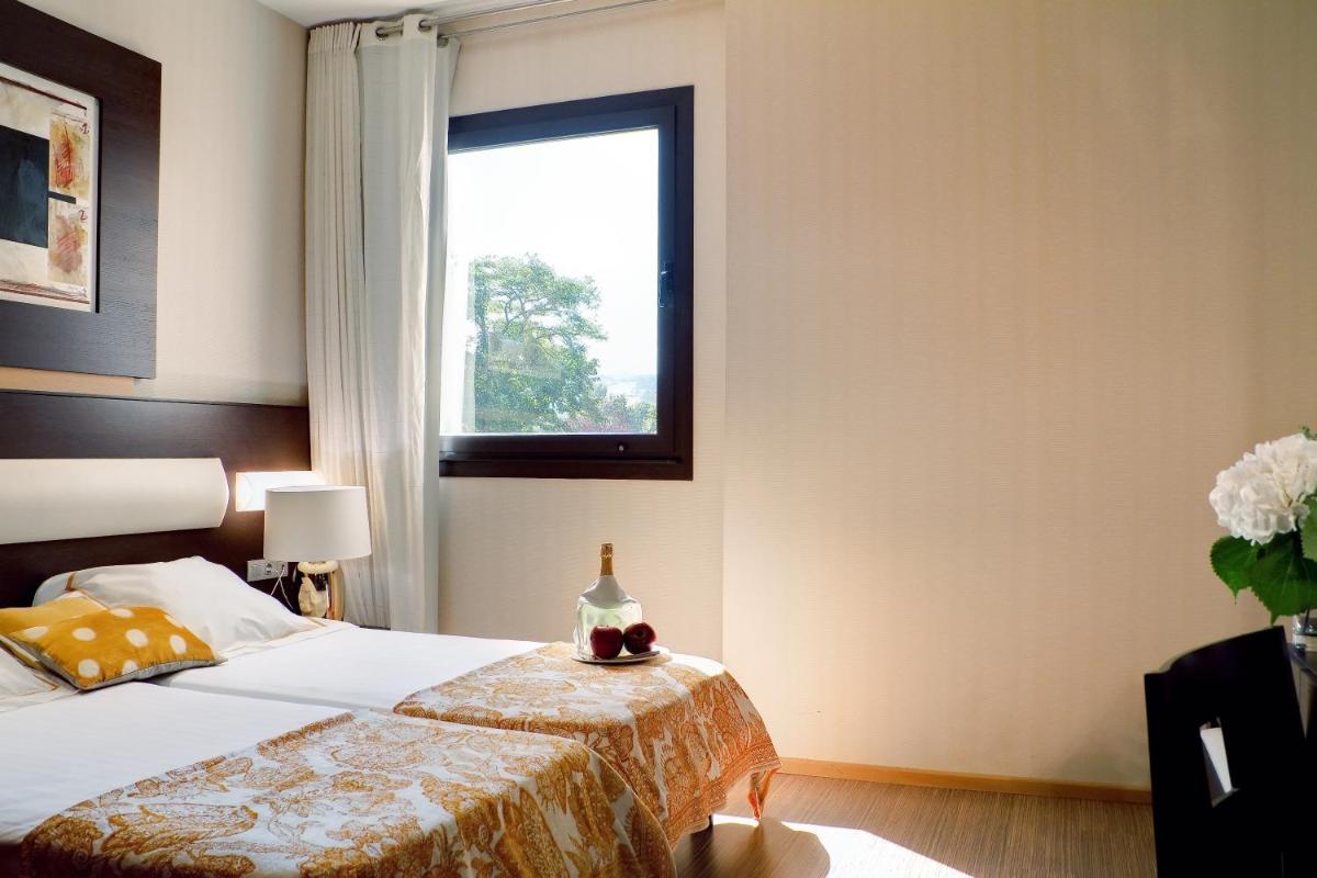 un dormitorio con una cama y una ventana en Oca Palacio De La Llorea Hotel & Spa, en Deva
