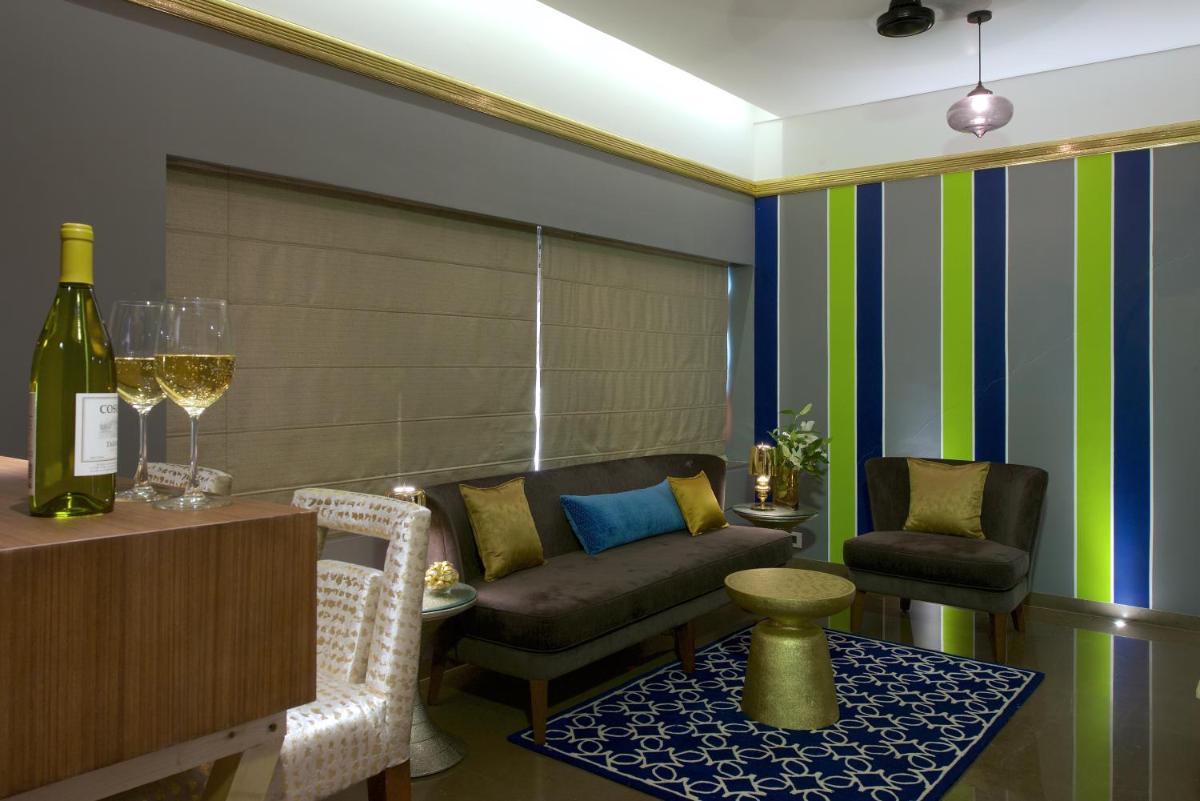 a living room with a couch and a bottle of wine at Hotel Lakend in Udaipur