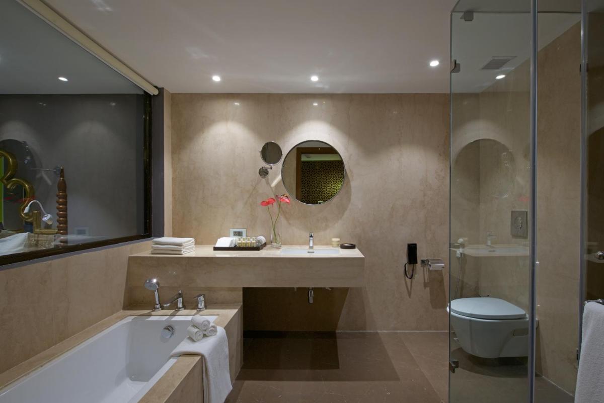 a bathroom with a tub and a sink and a shower at Hotel Lakend in Udaipur