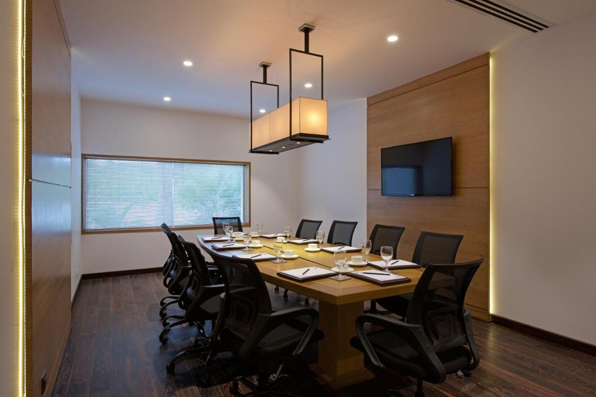 a conference room with a long table and black chairs at Hotel Lakend in Udaipur