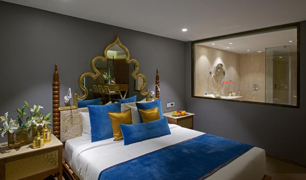 a bedroom with a large bed with blue and yellow pillows at Hotel Lakend in Udaipur