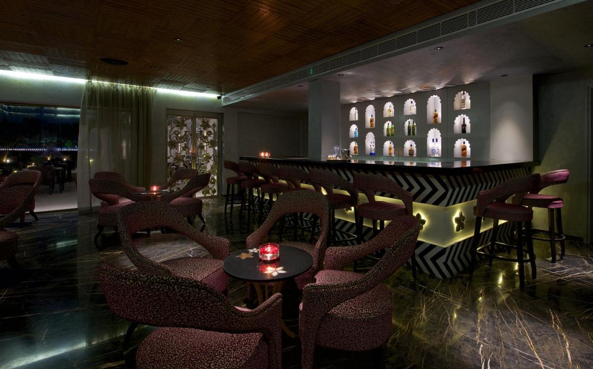 a bar with chairs and a counter in a room at Hotel Lakend in Udaipur