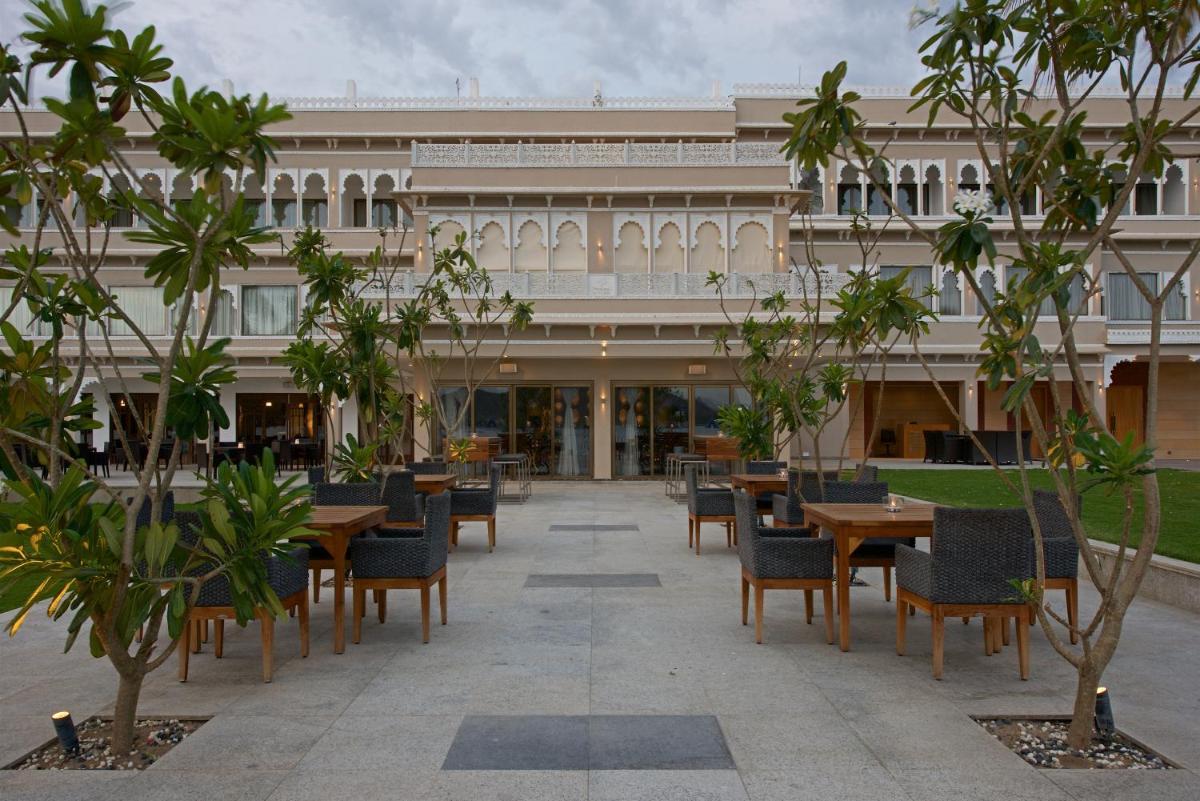 a courtyard with tables and chairs in front of a building at Hotel Lakend in Udaipur