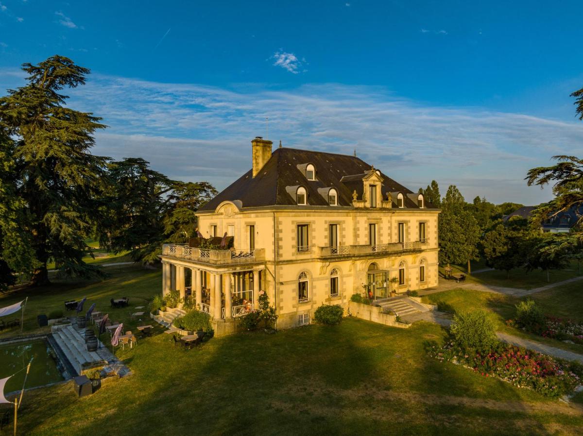 une grande maison sur un champ herbeux dans l'établissement Garrigae Manoir de Beauvoir Poitiers Sud - Hotel & Spa, à Mignaloux-Beauvoir