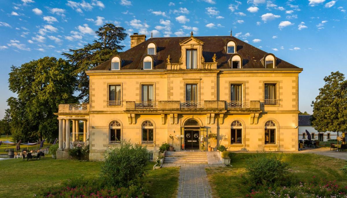 une grande maison jaune avec un toit dans l'établissement Garrigae Manoir de Beauvoir Poitiers Sud - Hotel & Spa, à Mignaloux-Beauvoir