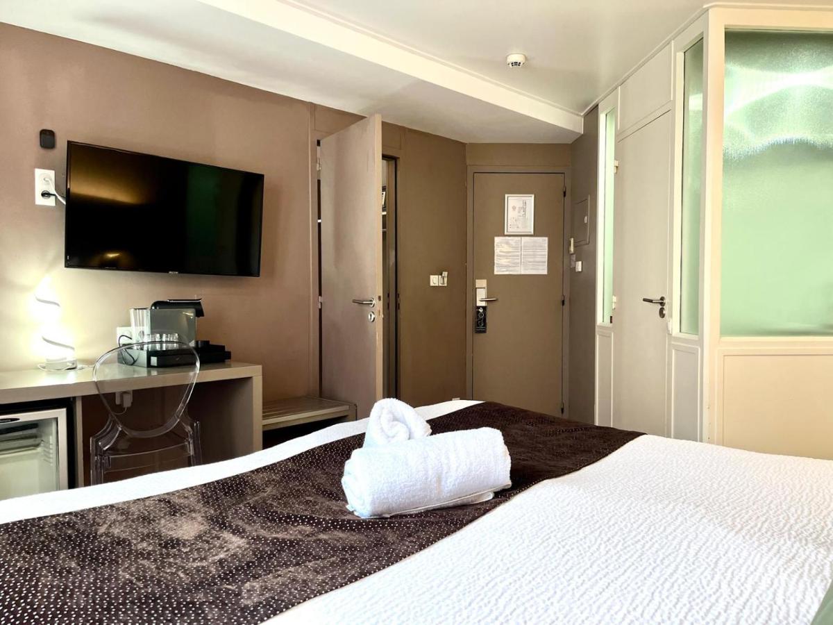 une chambre d'hôtel avec un lit et une serviette dessus dans l'établissement HOTEL & SPA Le Renard Centre, à Châlons-en-Champagne