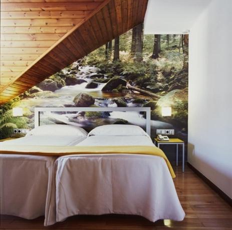 Un dormitorio con una cama con un cuadro de un río. en Hotel Restaurant Pessets & SPA, en Sort