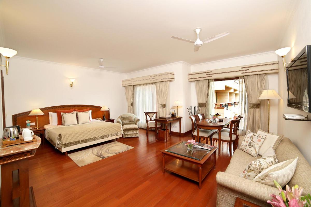 a large living room with a bed and a table at Jaypee Palace Hotel in Agra
