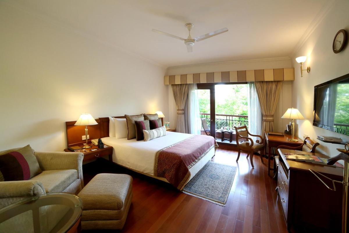 a hotel room with a bed and a couch at Jaypee Palace Hotel in Agra