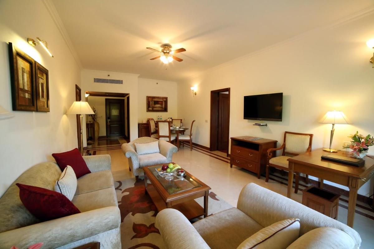 a living room with couches and a tv at Jaypee Palace Hotel in Agra