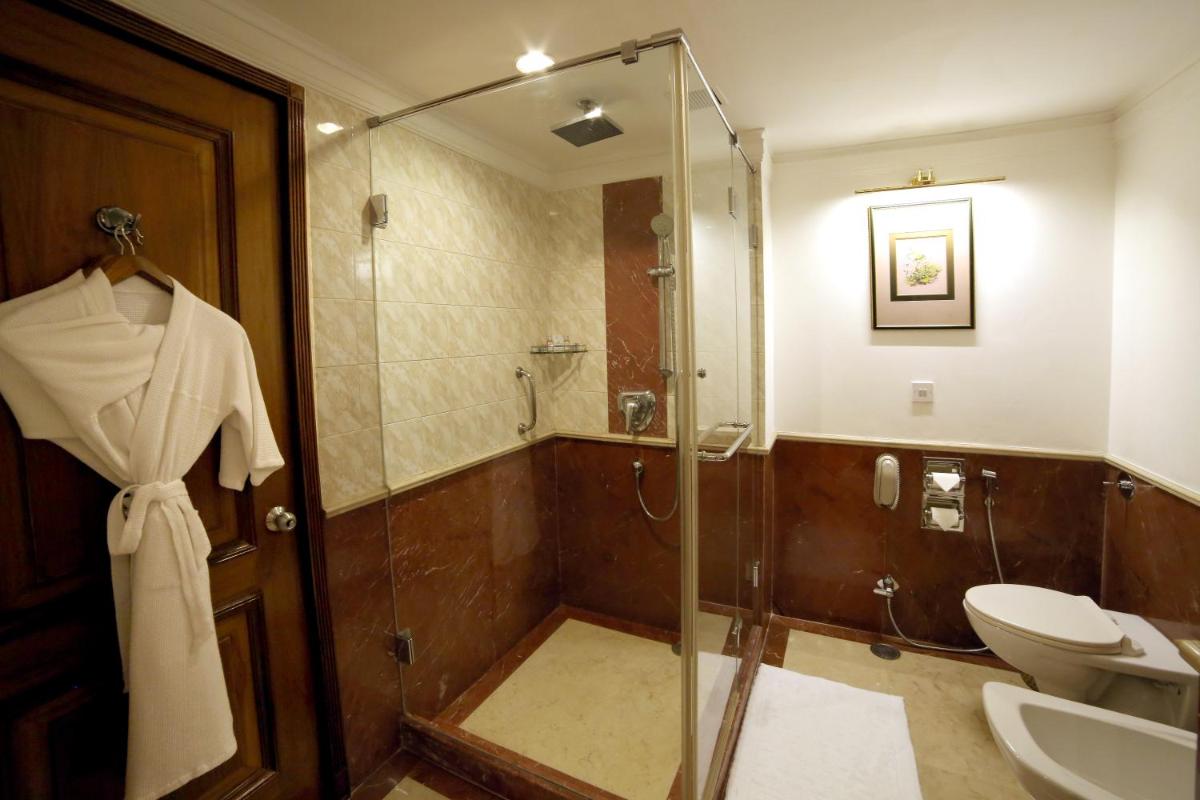 a bathroom with a shower and a toilet and a sink at Jaypee Palace Hotel in Agra