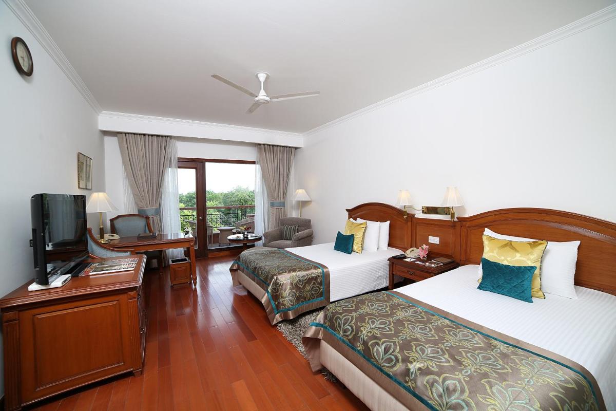 a hotel room with two beds and a flat screen tv at Jaypee Palace Hotel in Agra