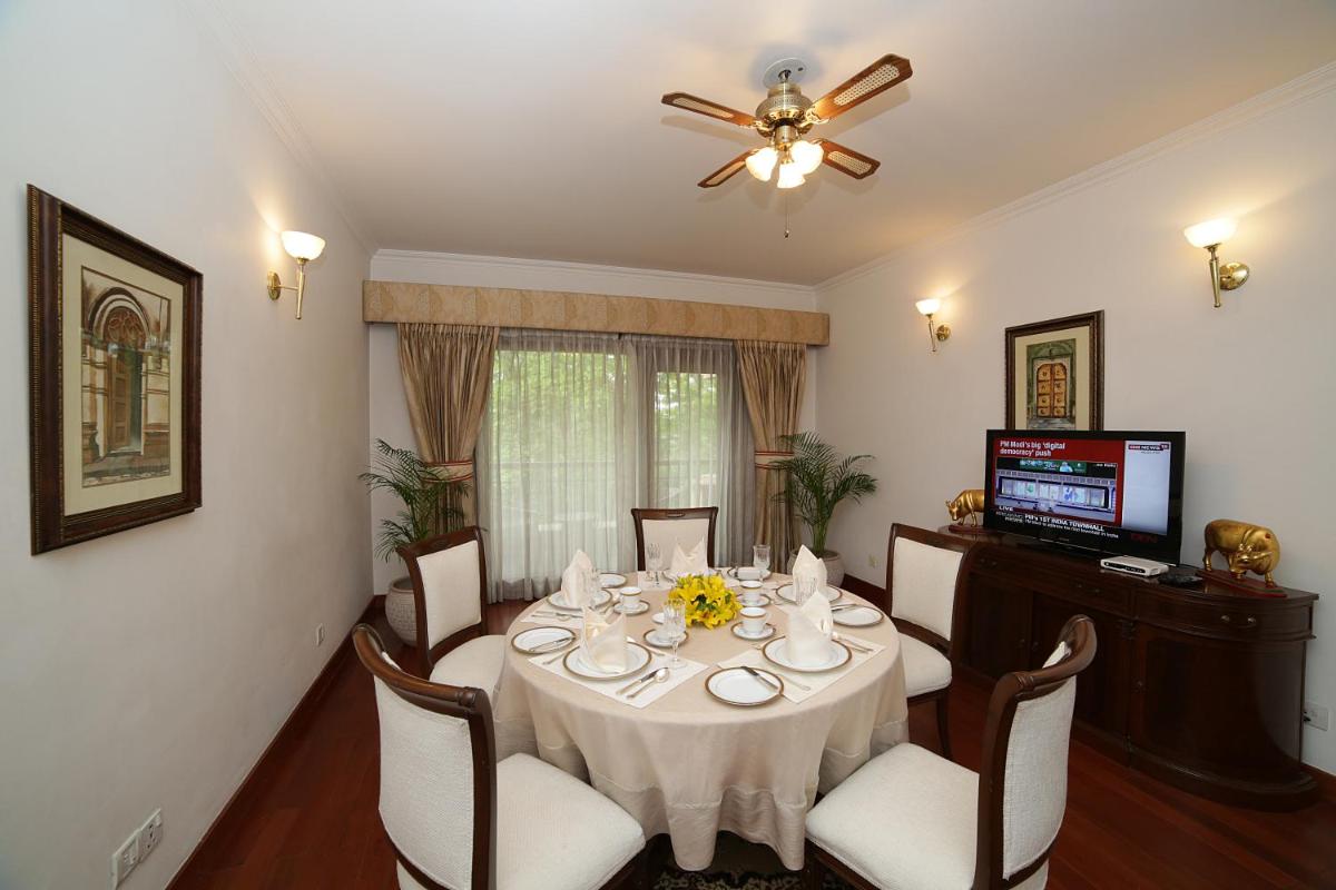 a dining room with a table with chairs and a ceiling fan at Jaypee Palace Hotel in Agra