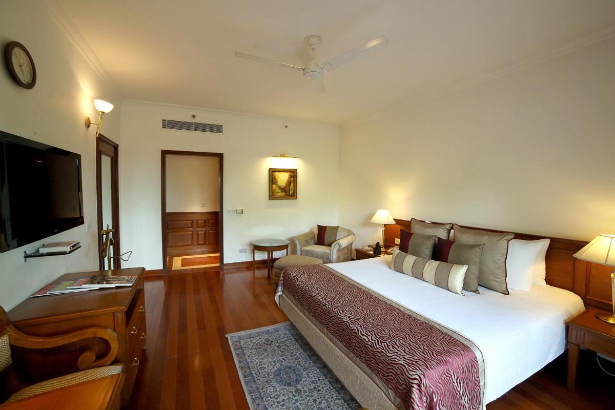 a bedroom with a large bed and a living room at Jaypee Palace Hotel in Agra